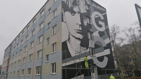 Czarno-biały, upamiętnia Grzegorza Ciechowskiego. Mural na budynku UMK